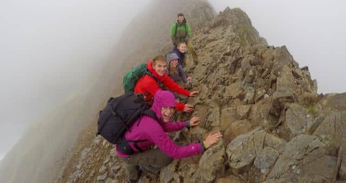 People scrambling on a high ridge