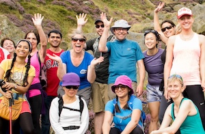 Happy group of trekkers on a challenge half way up a mountain in the Peak District