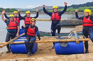 Team of people sitting on the raft they have built