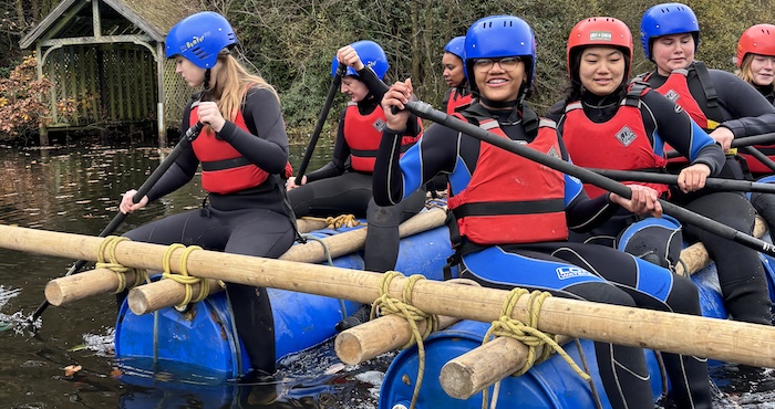 Group of school children rafting down a river